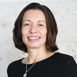 Headshot of Jessica Bega - smiling woman in black sweater with silver necklace
