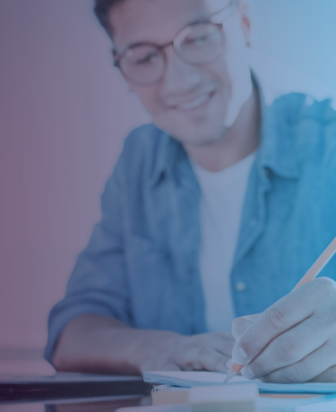 Young man in fashionable glasses taking paper test