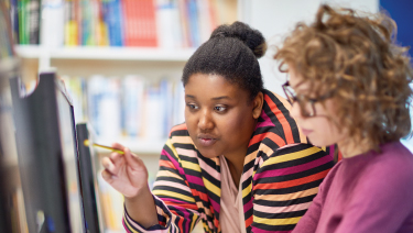 Woman helping student at computer
